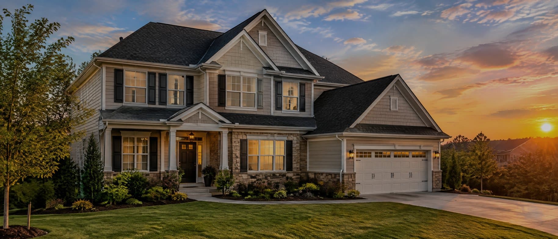 Two-story home with a new shingle roof at sunset